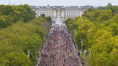 Crowd of runners participating in the Royal Parks Half Marathon with Buckingham Palace in the background.