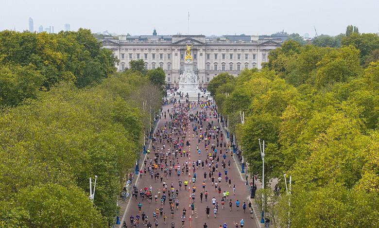 Crowd of runners participating in the Royal Parks Half Marathon with Buckingham Palace in the background.