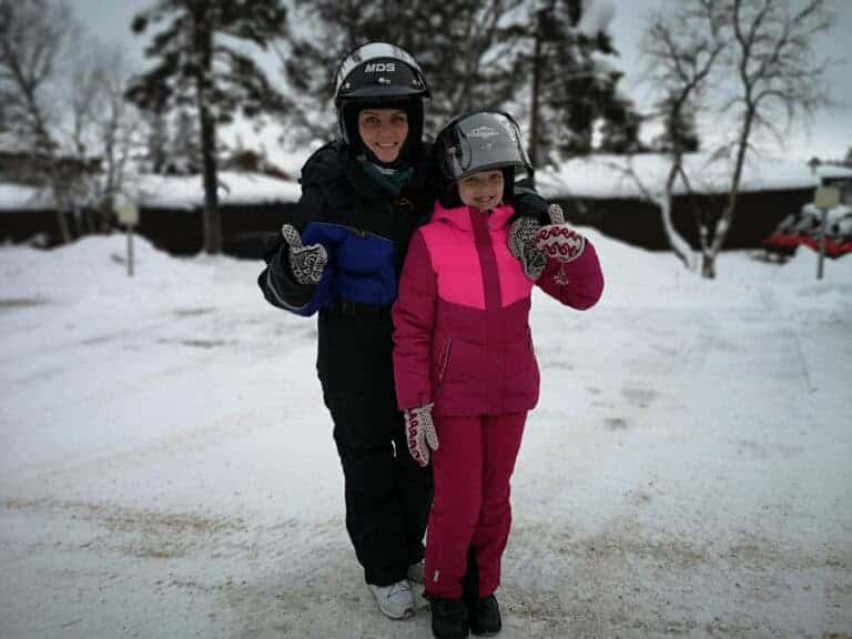Family enjoing snowmobile safari in Ivalo