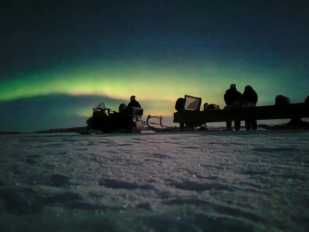 Northern Lights lake safari by snowmobile sleigh in Ivalo Lapland
