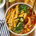 bowl of instant pot chicken tortilla soup with toppings.
