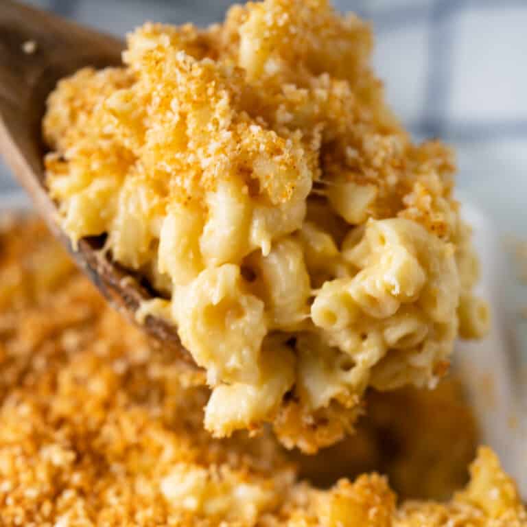 wooden spoon taking a spoonful of mac and cheese topped with breadcrumb