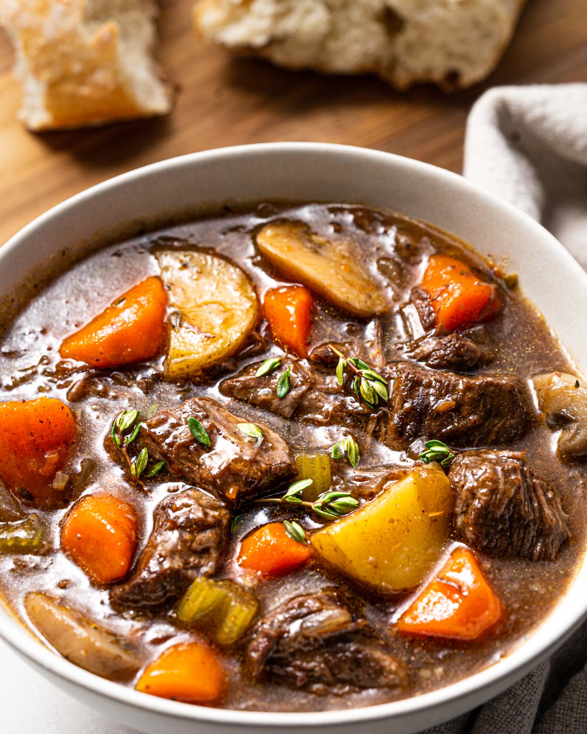 bowl of instant pot beef stew. Chunks of tender beef, carrots, potatoes, celery and mushrooms.