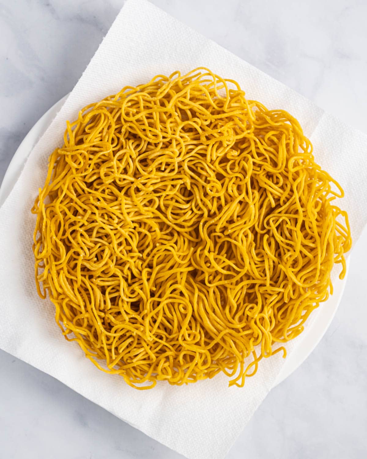 Noodles on a plate with a napkin after frying.