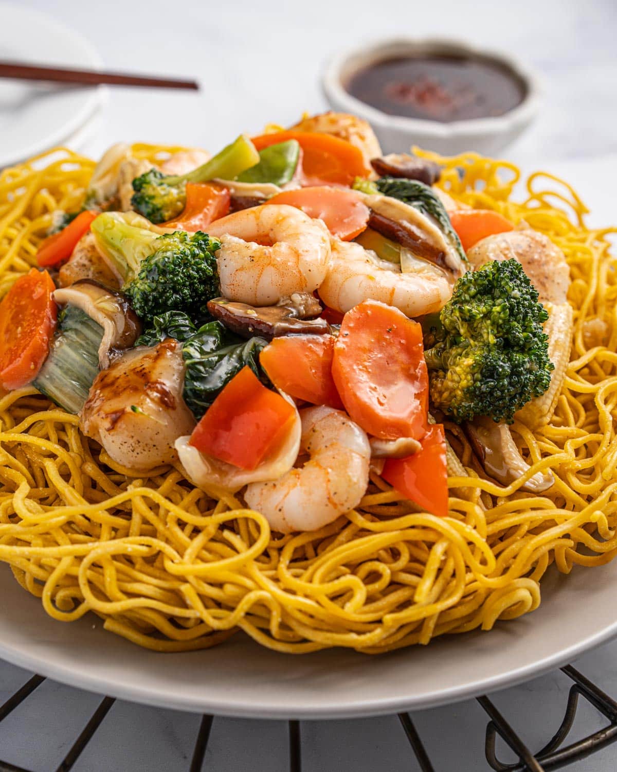 close up of fried noodles with stir-fried toppings and sauce.