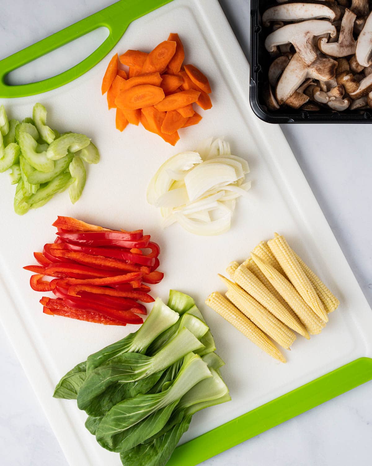Cutting up the vegetables: celery, carrots, red peppers, onions, baby bok choy, baby corn and mushrooms.