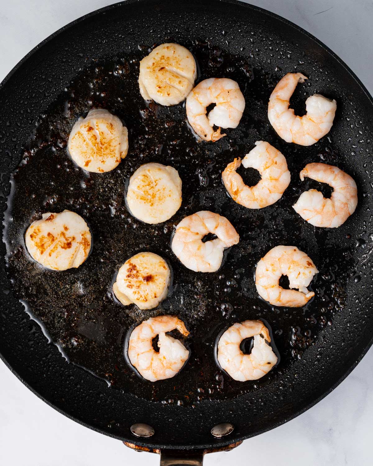 Cooking the shrimp and scallops on the pan.