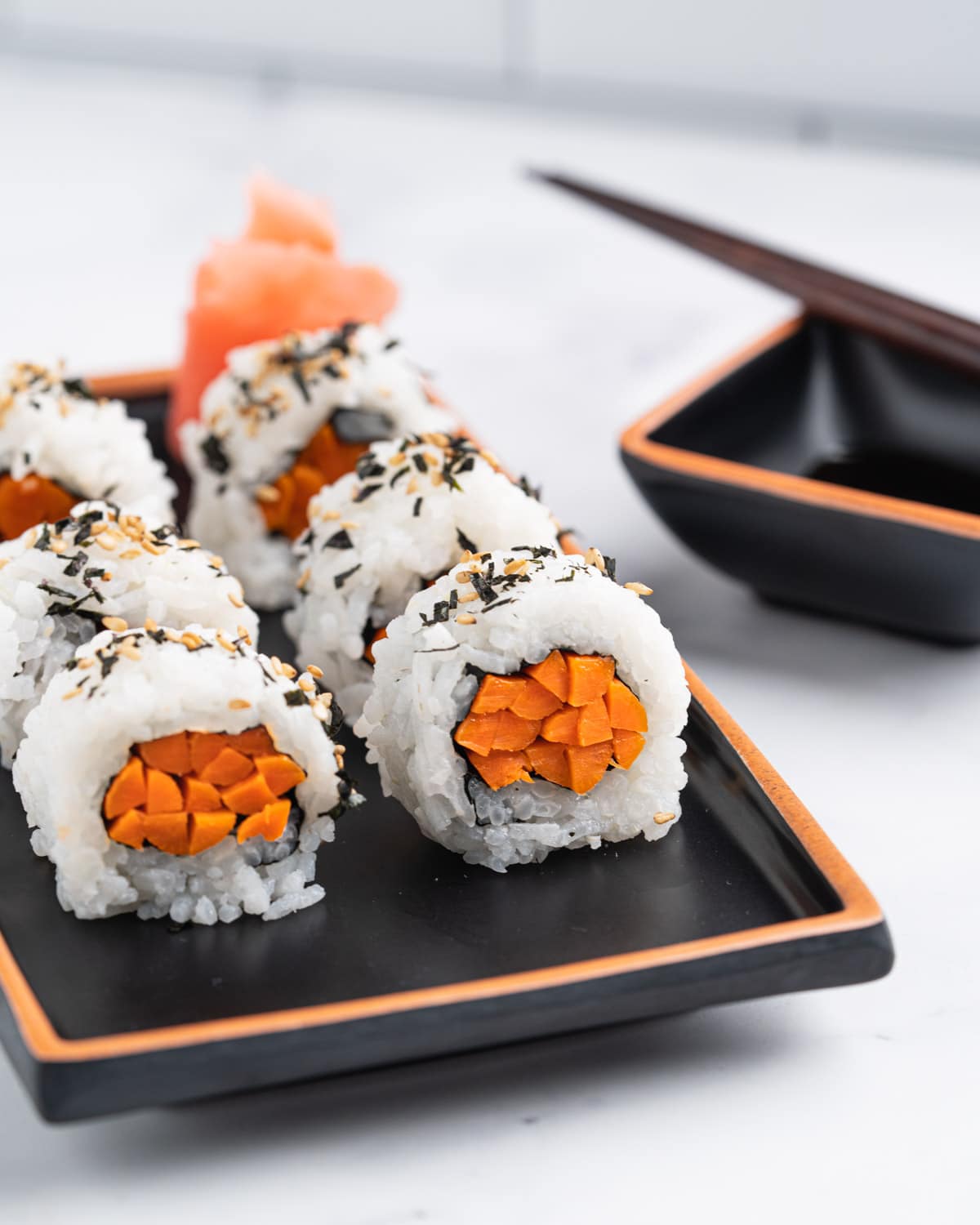 Plate of gobo sushi rolls standing up to show inside.
