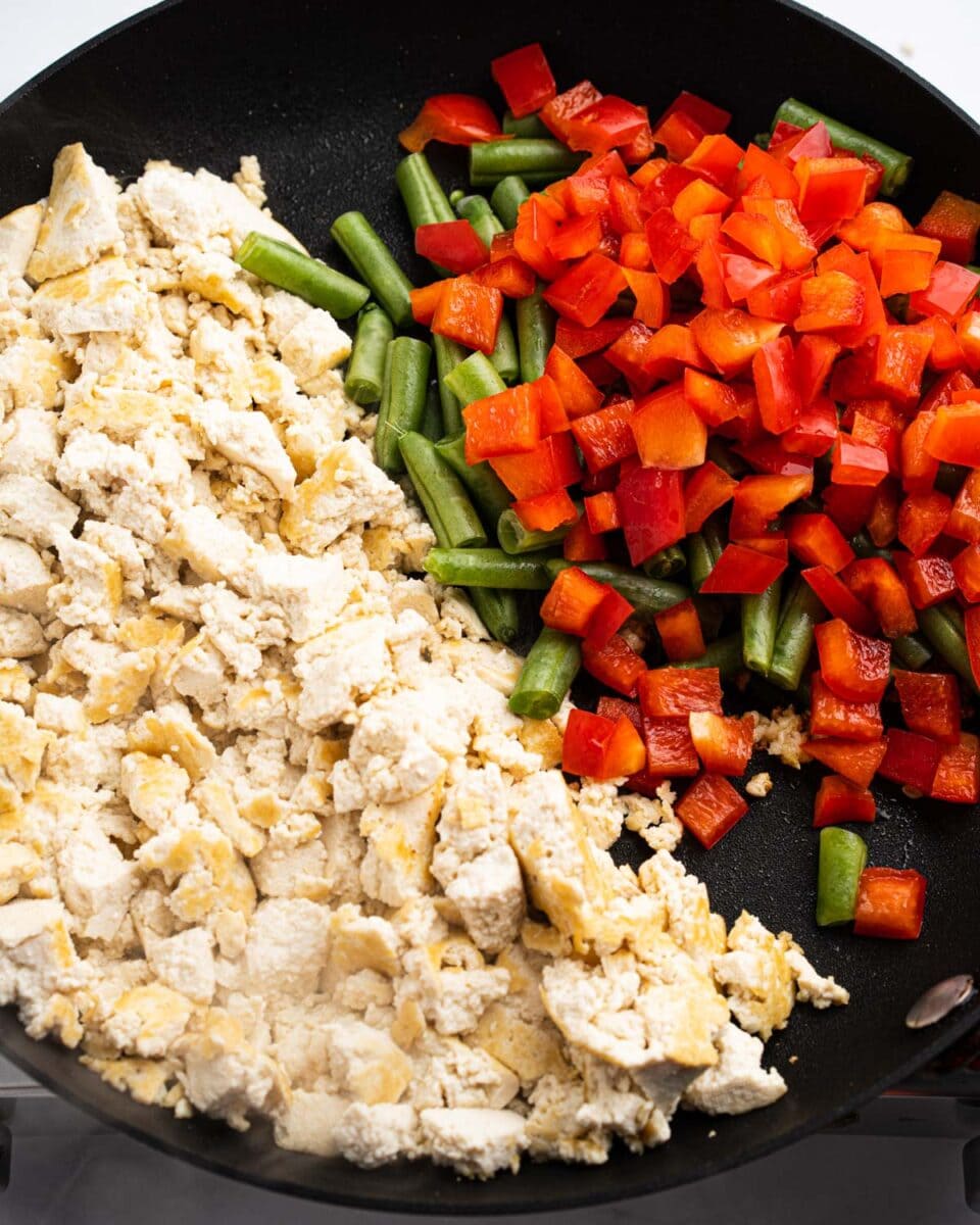 pan with stir fried tofu, green beans and red bell peppers.