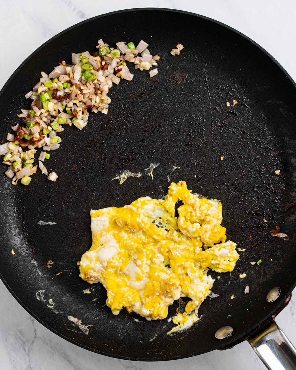 Sautéed shallots, scallions, and garlic on one side and scrambled eggs on the other.