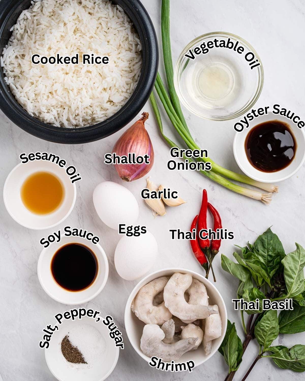 Ingredients needed for Thai Fried Rice: shrimp, cooked rice, vegetable oil, shallots, green onions, garlic, sesame oil, soy sauce, oyster sauce, salt, pepper, sugar, Thai chilis and Thai basil.