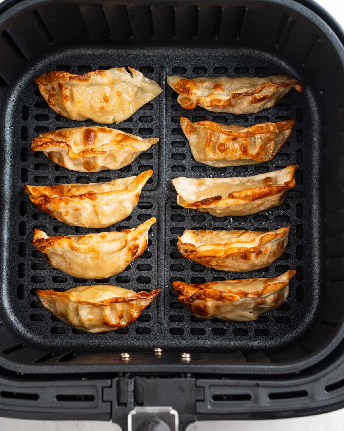 crispy dumplings in air fryer basket.