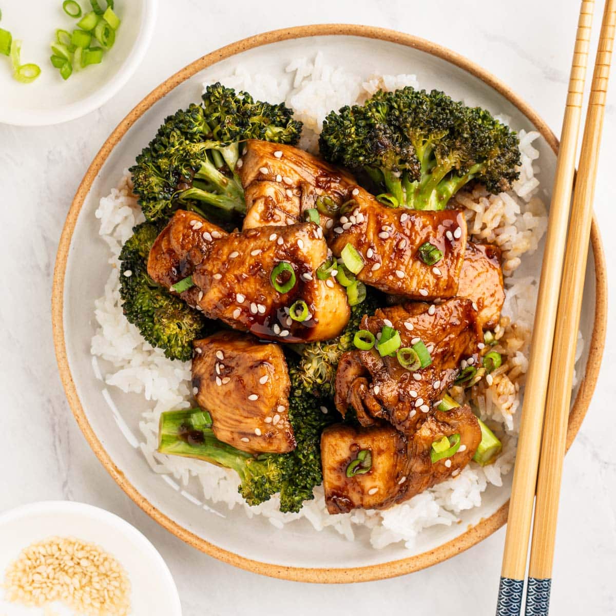 plate of teriyaki chicken and broccoli over white rice.