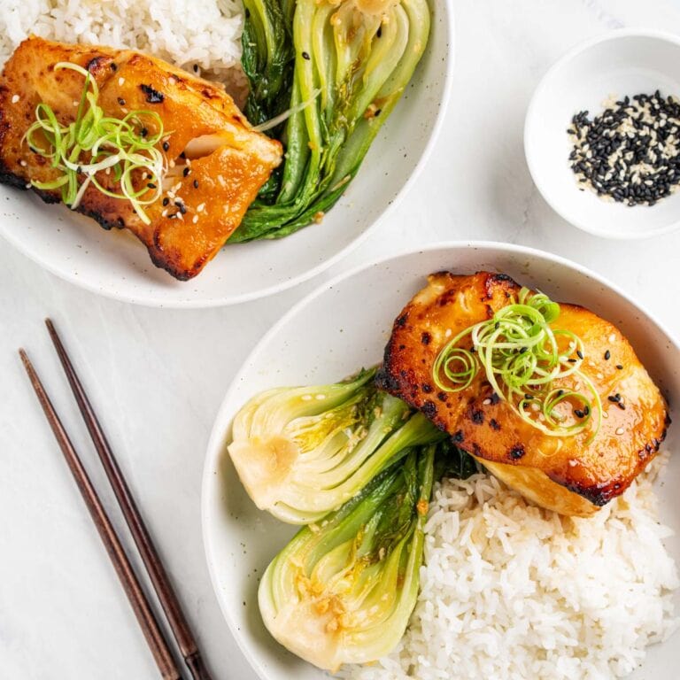two plates of miso cod with rice and baby bok choy.