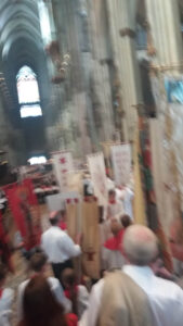 Schützenfest in einer Kathedrale mit festlicher Atmosphäre, Teilnehmer in traditionellen Trachten, Tragen von Standarten und Bannern, religiöse und kulturelle Feierlichkeit, Gemeinschaft der Schützenbrüder.