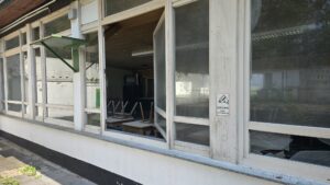 Verlassene, zerbrochene Fenster und eine beschädigte Außenwand des Schützenhauses mit einem Warnschild in Köln.