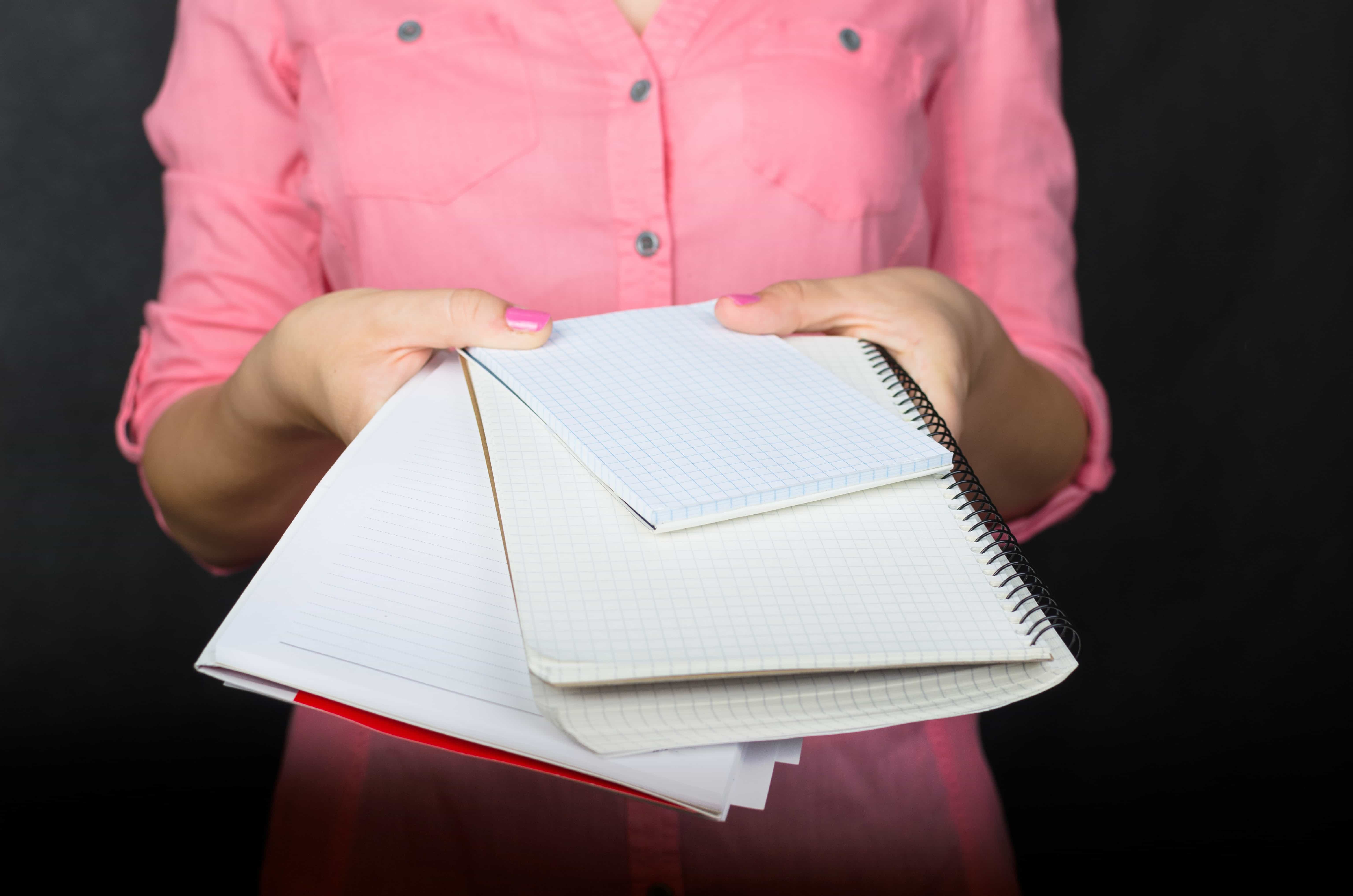 a woman holding notebooks