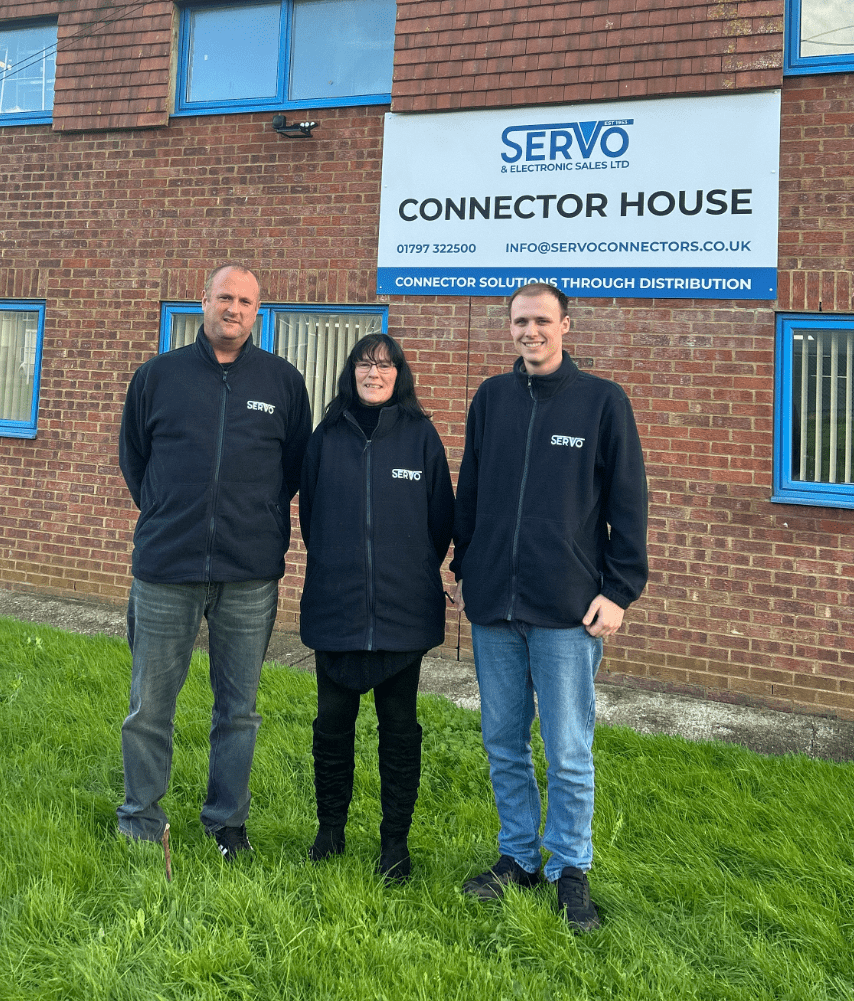 Three members of the Servo team in front of the company building.