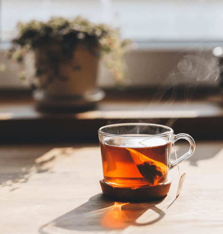 A cup of steaming green tea catching beautiful sunlight from the window.