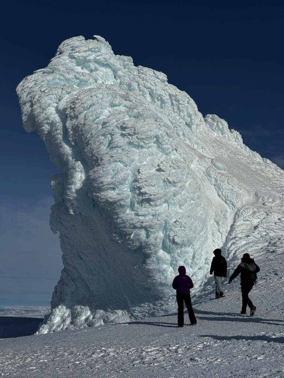A large ice standing up in the air and people standing below it on Eyjafjallajokull Super jeep tour with Southcoast Adventure