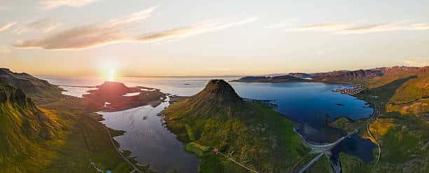 A stunning aerial view captures the iconic Kirkjufell mountain in silhouette against a breathtaking sunset.