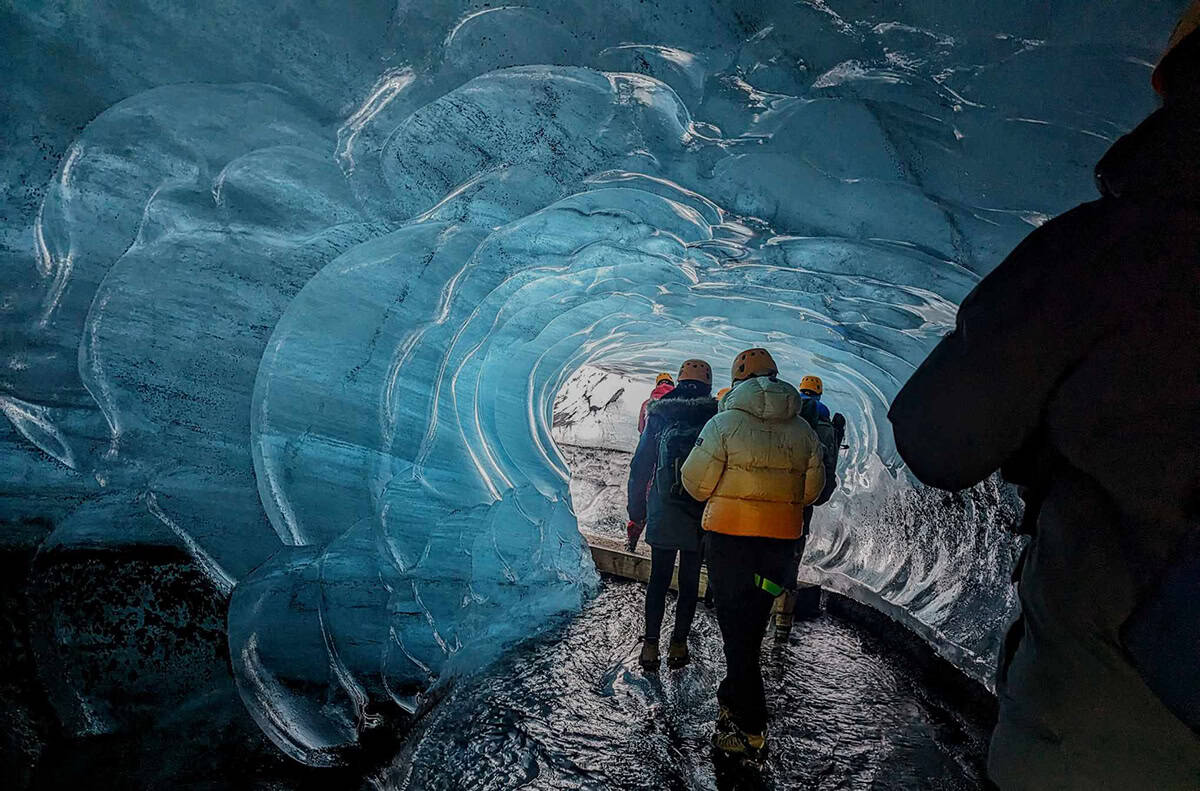 People walking inside an ice cave of Katla Ice Cave on an adventour tour from Southcoast Adventure