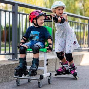 Kinder beim Rollschuhlaufen und Rollstuhl im Park.
