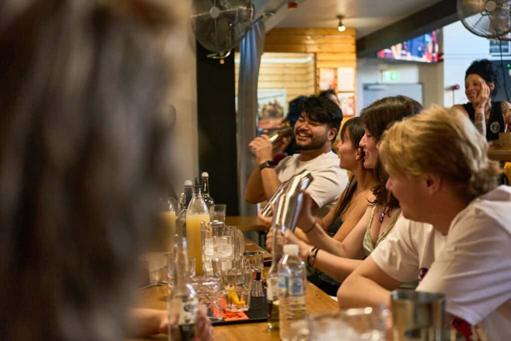 Lively bar scene at Flying Pig Downtown Hostel with guests enjoying drinks and socialising.