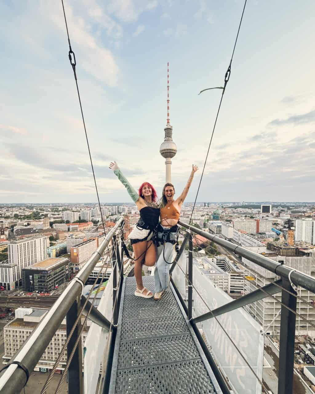 Rooftop view from Flying Pig Downtown Hostel in Berlin, featuring two happy guests on the rooftop wi.