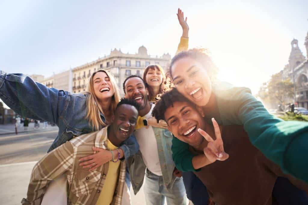 Vibrant group of diverse friends taking a selfie in downtown near Flying Pig Hostel.