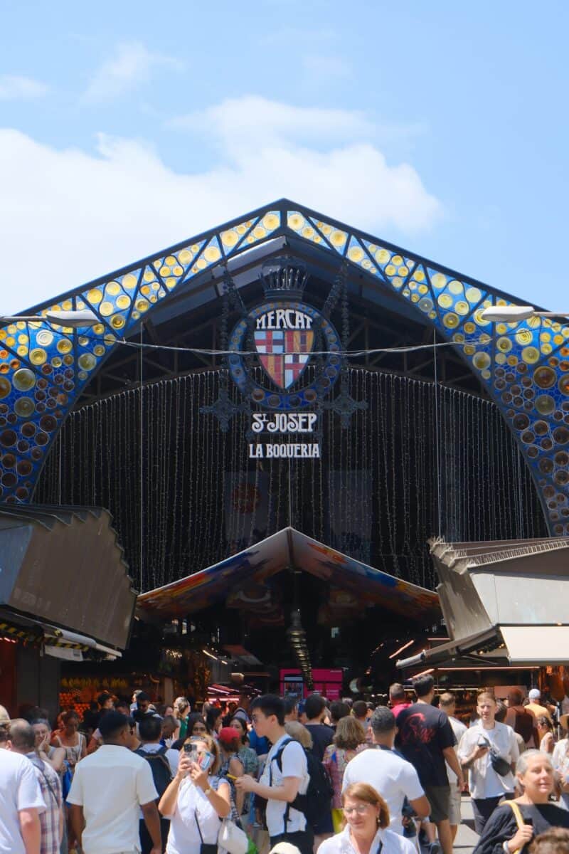Exterior view of Flying Pig Downtown Hostel in Amsterdam with vibrant design and crowd.