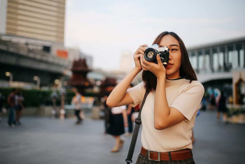 Young woman taking photos outside Flying Pig Downtown Hostel in the city centre.