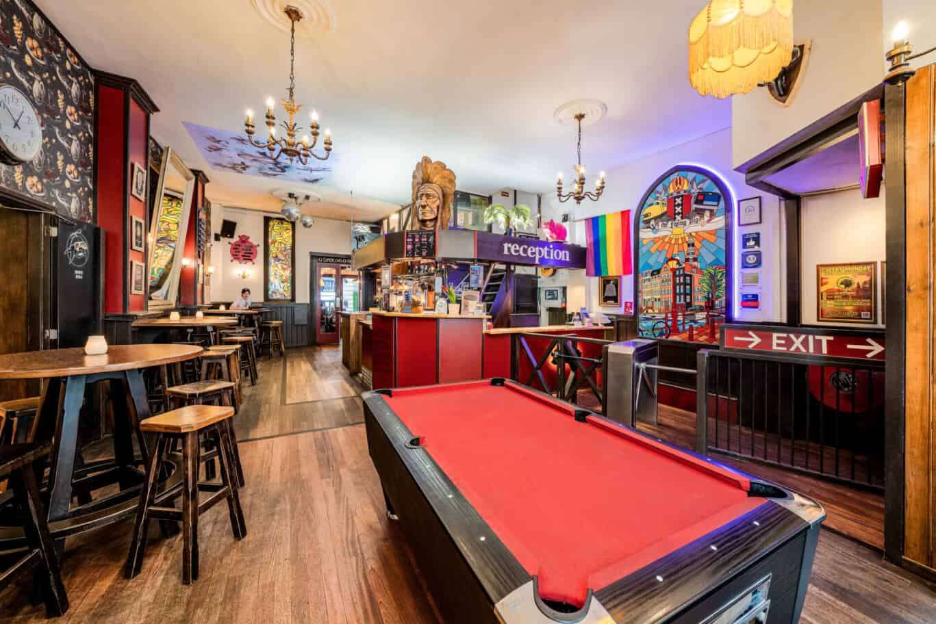 Bright hostel interior featuring a pool table, eclectic artwork, and colourful lighting in downtown.
