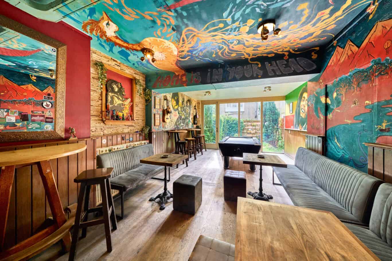 Bright hostel lounge featuring colourful, artistic murals and comfortable seating areas. Perfect for.