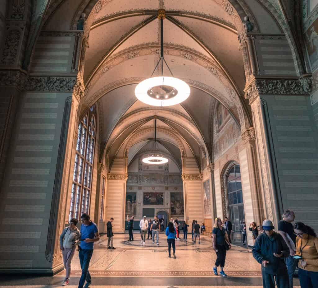 Interior of a grand historic train station with high vaulted ceilings and intricate decorative eleme.