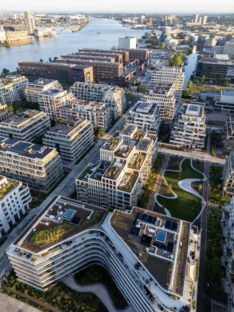 Aerial view of downtown Amsterdam with modern buildings and waterways, near The Flying Pig hostels.