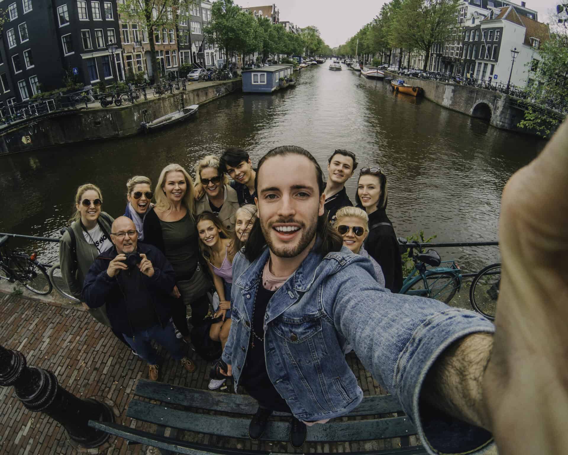 Group of young travellers at The Flying Pig Downtown hostel in Amsterdam by a canal.