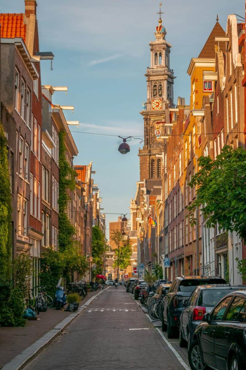 City street view near The Flying Pig Downtown hostel in Amsterdam with historic buildings and a tall.