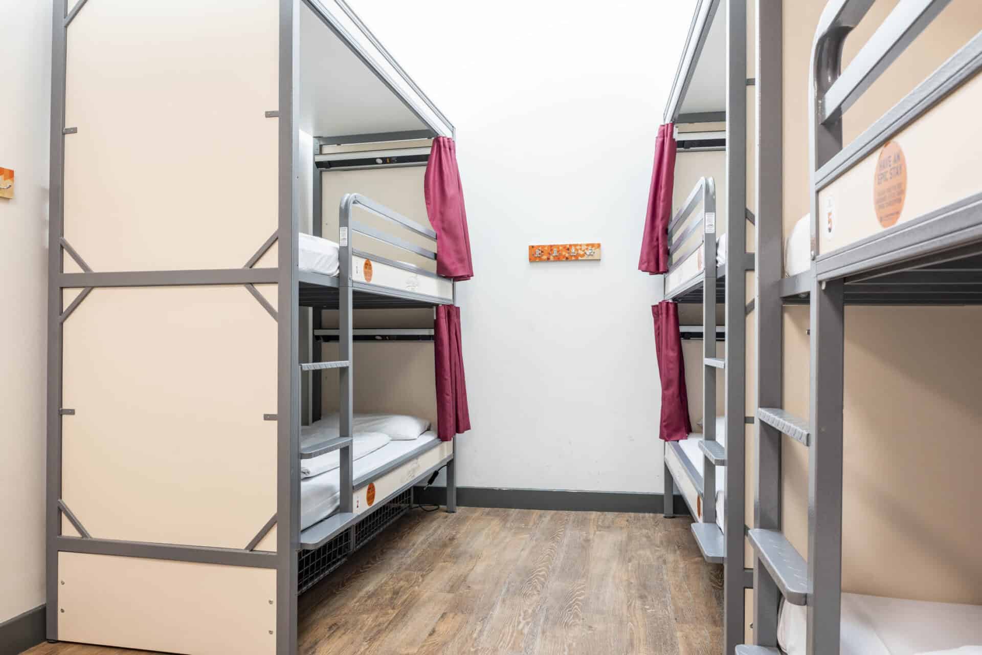 Bunk beds in a hostel dormitory at St Christopher's Edinburgh, featuring metal frames and privacy cu.