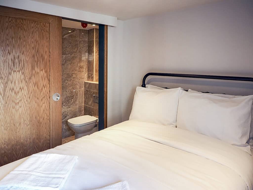 Bright, clean bedroom with a comfortable bed and en-suite bathroom.