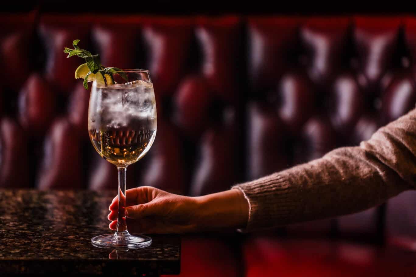 A refreshing cocktail garnished with mint, served in a tall glass at Liverpool Street Hostel bar.