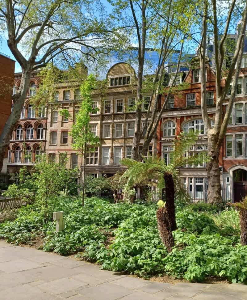 Exterior view of St Christopher's Liverpool Street with garden and historic buildings.