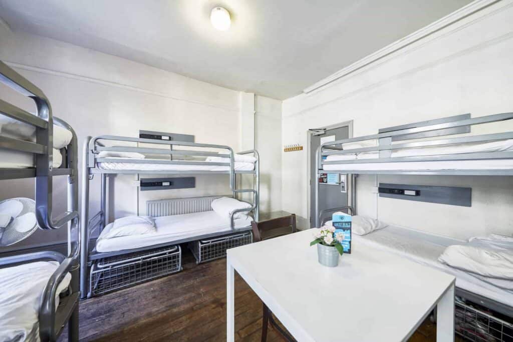 Shared dorms at St Christopher's Inn London Bridge - The Inn with metal bunk beds and a small table.