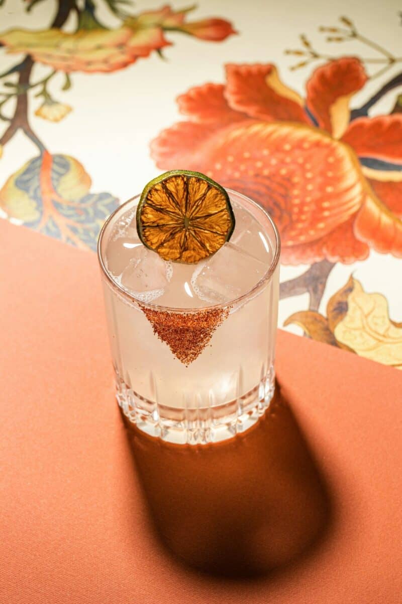 St Christopher's Inn London Bridge - The Inn cocktail with lemon slice on a colourful table.