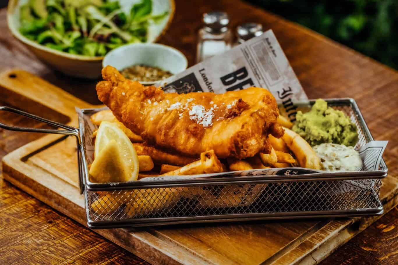 Traditional fish and chips at St Christopher's Inn London Bridge - The Inn, with side salad and cond.