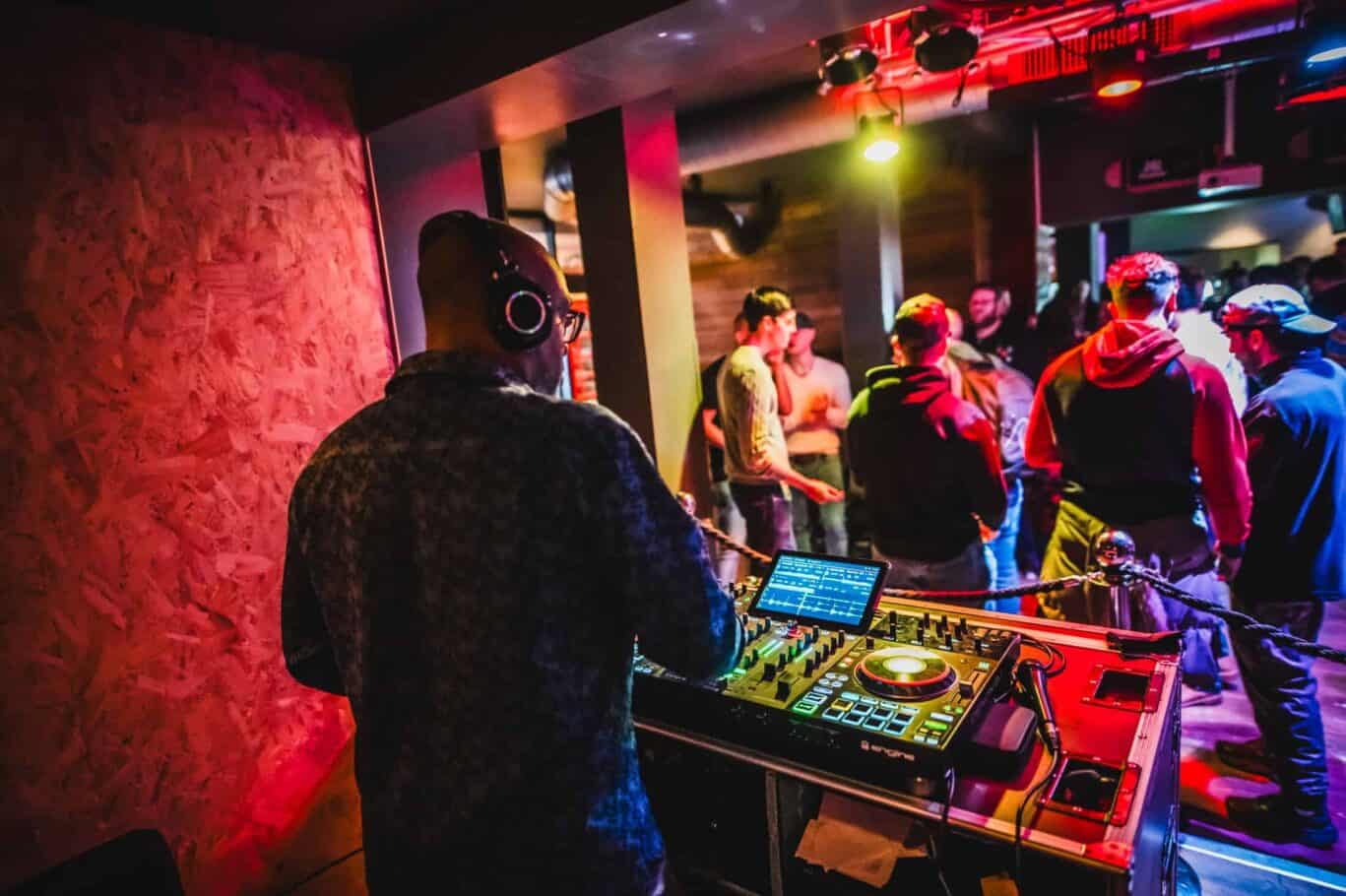 DJ performing at London Bridge hostel with guests dancing and enjoying the vibrant atmosphere.