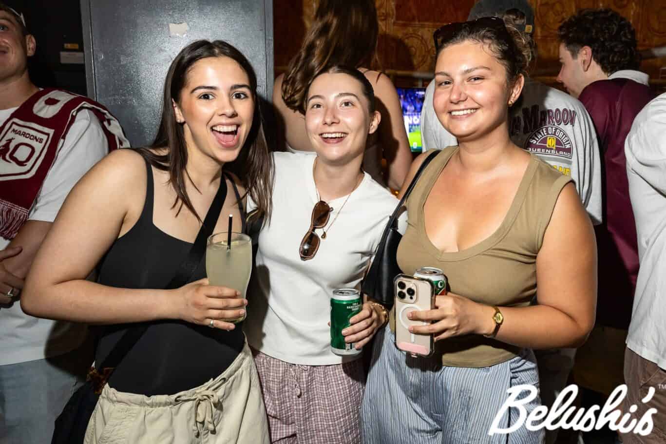Group of young women enjoying drinks and taking photos at London Bridge Hostel event.