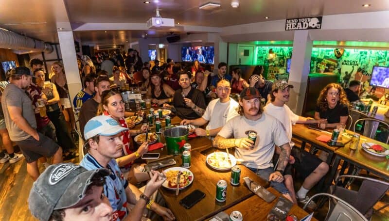 St Christopher's London Bridge - The Village bar with guests watching sports on TV.