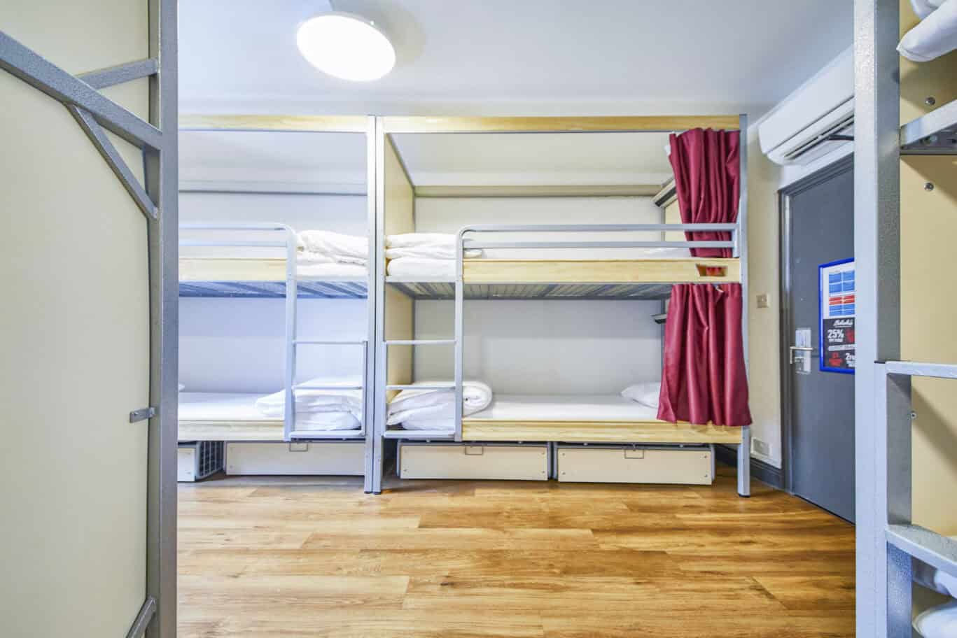 Dorm room at St Christopher's London Bridge hostel with bunk beds and privacy curtains.