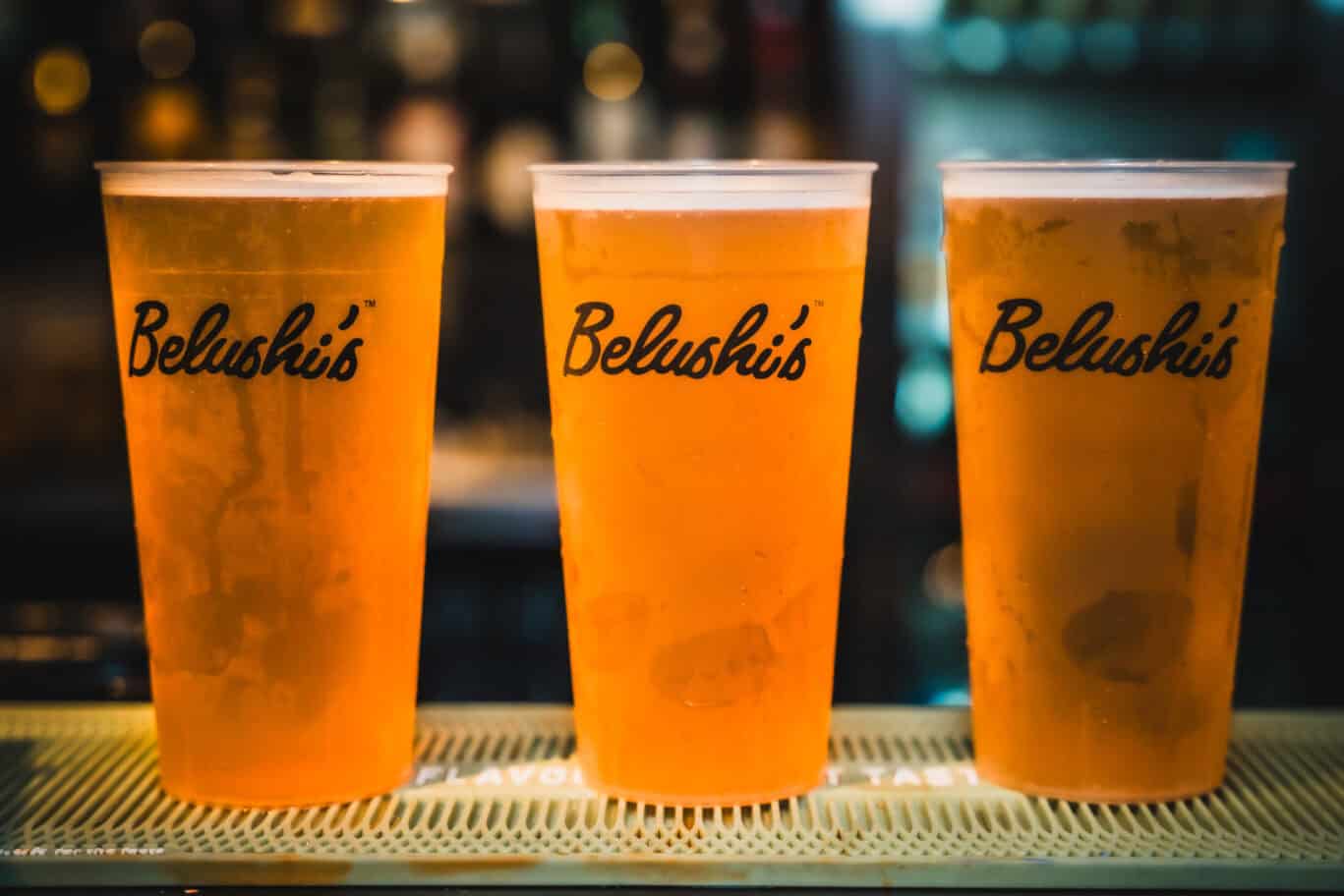 Three pints of beer on a bar at Belushi's, Newquay hostel, Cornwall, UK.